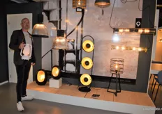 Accountmanager Dirk Jansen van Qazqa, poserend voor een deel van de collectie, met in zijn hand tafellamp Storm Music, voorzien van een bluetooth speaker.